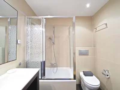 a bathroom with a shower and a toilet and a sink at BCN | Duplex Penthouse & Pool in Sant Andreu de Llavaneres