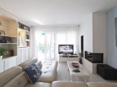 a living room with a couch and a tv at BCN | Duplex Penthouse & Pool in Sant Andreu de Llavaneres