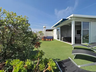 a backyard of a house with a lawn at BCN | Duplex Penthouse & Pool in Sant Andreu de Llavaneres