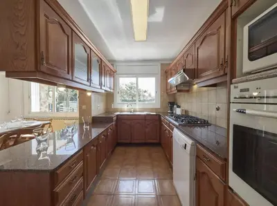 a kitchen with wooden cabinets and a counter top at Villa Julia | 14pax. 5' sea & train in Sant Andreu de Llavaneres