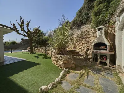 a stone wall with an outdoor oven in a yard at Villa Julia | 14pax. 5' sea & train in Sant Andreu de Llavaneres
