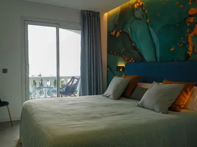 a bedroom with a large bed with a large window at Bluehillsitges - Only Adults in Sitges