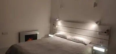 a bedroom with a bed and a fireplace at Apartamento con vistas al mar in Viladecáns