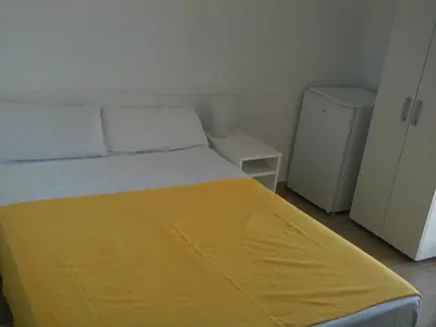 a bedroom with a bed with a yellow blanket on it at Hostal Cubelles in Cubelles