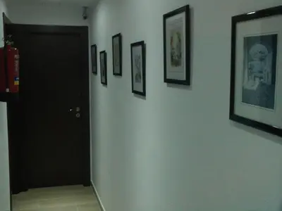 a hallway with a black door and pictures on the wall at Hostal Cubelles in Cubelles