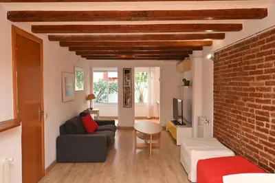 a living room with a couch and a brick wall at Homenfun Barcelona Poblenou in Barcelona
