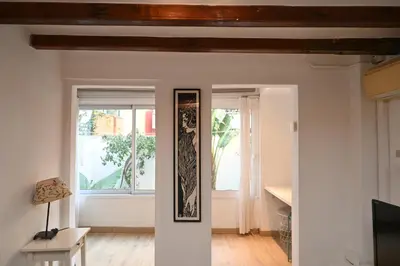 a living room with white walls and wooden ceilings at Homenfun Barcelona Poblenou in Barcelona
