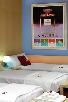 two beds in a room with a poster on the wall at Apartamento Granollers in Granollers