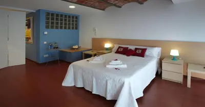 a bedroom with a large white bed with red pillows at Apartamento Granollers in Granollers