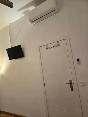 a bathroom with a door and a air conditioner on the wall at Casa Acogedora in Hospitalet de Llobregat