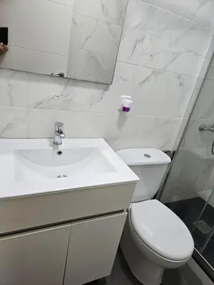 a white bathroom with a toilet and a sink at Casa Acogedora in Hospitalet de Llobregat