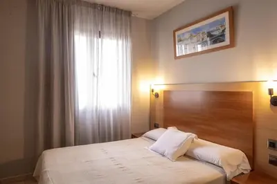 a bedroom with a bed with a large window at Hotel Sant Celoni in San Celoni