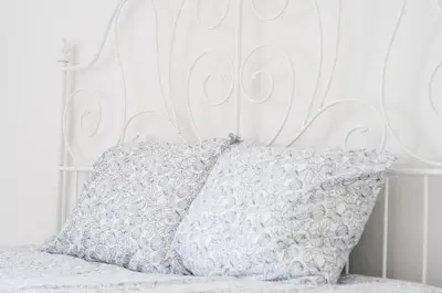 a white bed with a white headboard and a pillow at Pubone AT Sabadell in Sabadell