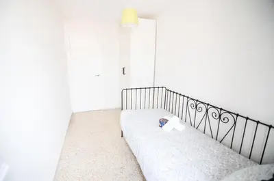 a bed in a white room with a lamp at Pubone AT Sabadell in Sabadell