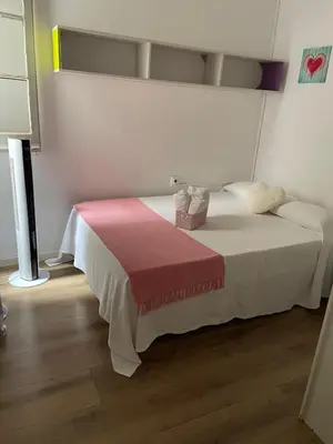 a bedroom with a white bed with a red blanket at Alojamiento muy cómodo in Hospitalet de Llobregat