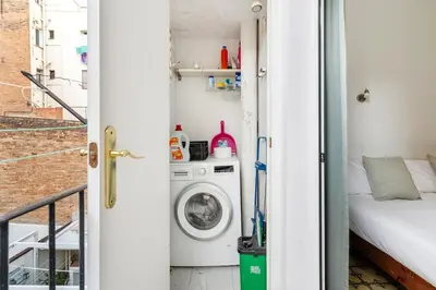 a small apartment with a washing machine in a room at Progres in Barcelona