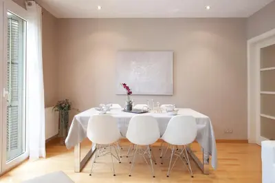 two beds in a room with white walls and wooden floors at Gran Via modern and bright 3BD with terrace in Barcelona