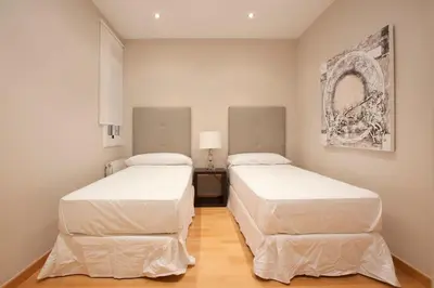 a white dining room with a table and white chairs at Gran Via modern and bright 3BD with terrace in Barcelona