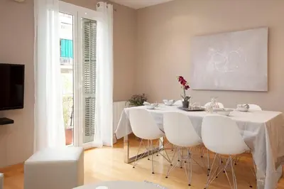 a bedroom with a white bed with a large window at Gran Via modern and bright 3BD with terrace in Barcelona