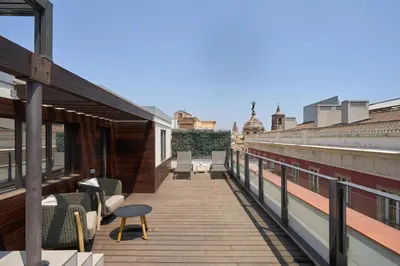 a balcony with chairs and tables on a building at Catalonia Port in Barcelona