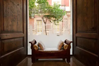 a chair with pillows sitting in a room with a window at Catalonia Port in Barcelona