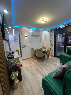 a living room with a green couch and a table at Piso luxori in Santa Coloma de Gramanet