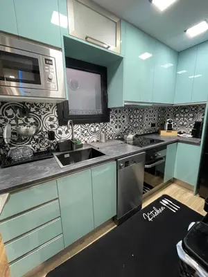 a kitchen with blue cabinets and a sink and a microwave at Piso luxori in Santa Coloma de Gramanet