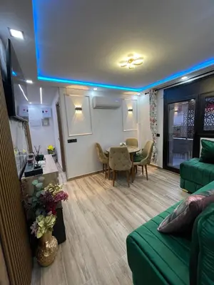 a living room with a green couch and a table at A comfortable apartment in Santa Coloma de Gramanet