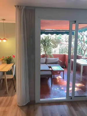 a living room with a couch and a table at Beach apartment 2 terraces with parking in Castelldefels