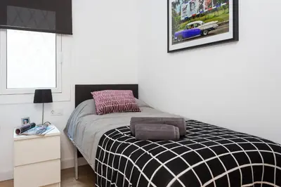 a bedroom with a bed with a black and white blanket at Opening Doors Sagrada Familia II in Barcelona