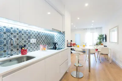 a kitchen with a sink and a table with chairs at Opening Doors Sagrada Familia II in Barcelona