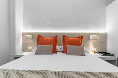 a bedroom with a bed with orange pillows at Acacia Suite in Barcelona