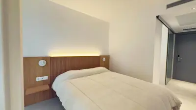 a bedroom with a bed and a large window at MYO Barcelona Hotel & Apartments in Castelldefels