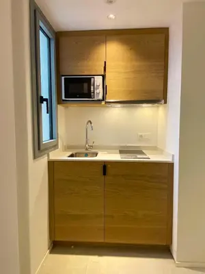 a kitchen with a sink and a microwave at MYO Barcelona Hotel & Apartments in Castelldefels