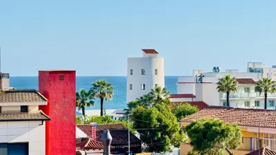 a view of a city with buildings and the ocean at MYO Barcelona Hotel & Apartments in Castelldefels