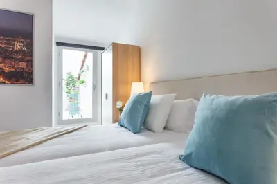 a bedroom with a bed with blue and white pillows at Apartamentos Cornellalux in Cornellà de Llobregat