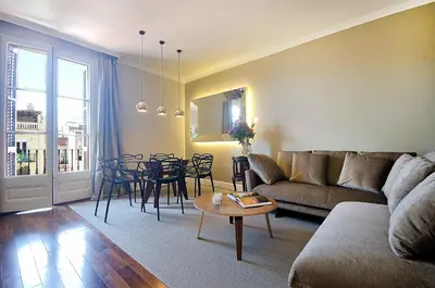 a living room with a couch and a table and chairs at Three bedroom apartment in Gran de Gracia - You Stylish Apartments in Barcelona