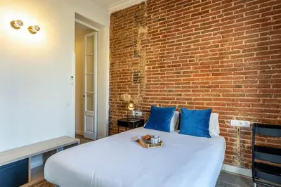 a room with a bed and a brick wall at 4305 - AB Eixample Sepúlveda 157 in Barcelona