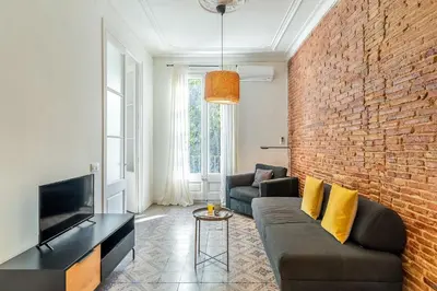 a living room with a couch and a brick wall at 4305 - AB Eixample Sepúlveda 157 in Barcelona