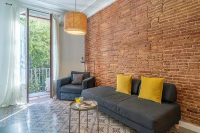 a living room with a couch and a brick wall at 4305 - AB Eixample Sepúlveda 157 in Barcelona