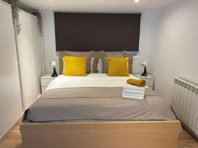 a bedroom with a large bed with yellow pillows at Apartment close Barcelona - Rentals Badalona Beach - Free Parking in Badalona