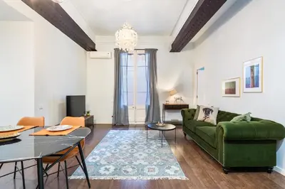 a living room with a green couch and a table at Muntaner in Barcelona