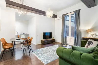 a living room with a green couch and a table at Muntaner in Barcelona