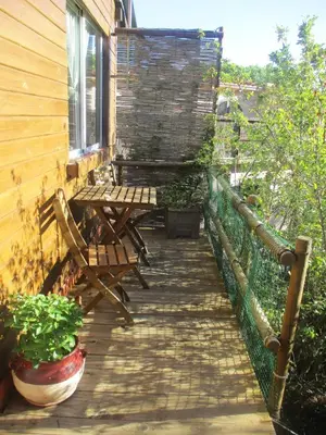a porch with chairs and a table on a house at Climbers Cabin in Marganell