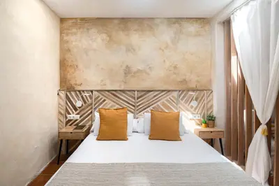 a bedroom with a large bed with yellow pillows at Rainbow Sitges in Sitges