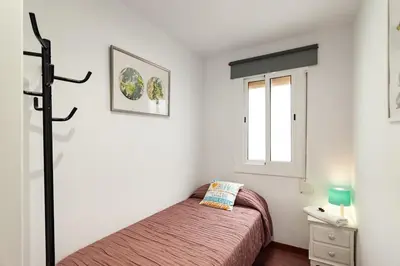 a small bedroom with a bed and a window at Camp nou Apartamento in Hospitalet de Llobregat