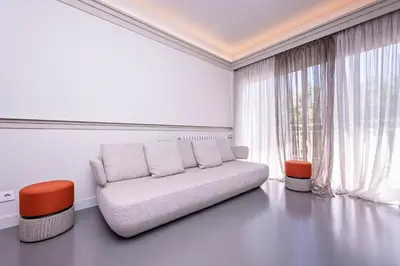 a white living room with a couch and a window at Sweett - Gaudi Avenue in Barcelona