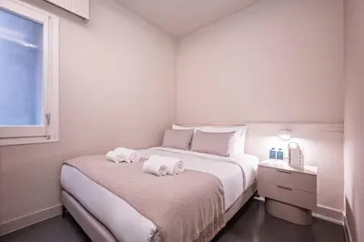 a white bedroom with two towels on a bed at Sweett - Gaudi Avenue in Barcelona