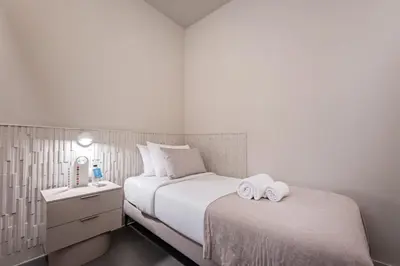 a bedroom with two beds and a nightstand with towels at Sweett - Gaudi Avenue in Barcelona