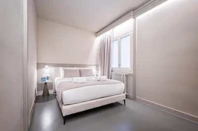 a white bedroom with a large bed and a window at Sweett - Gaudi Avenue in Barcelona